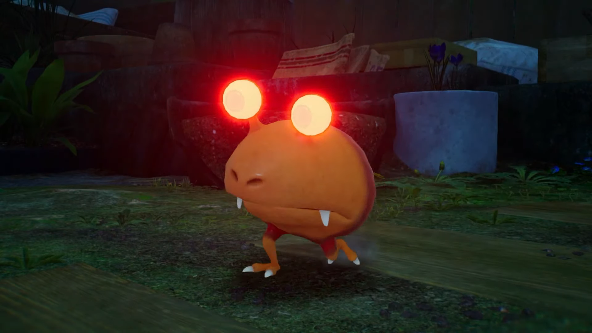 A glowing-eyed enemy with a big mouth walks through a grassy area.