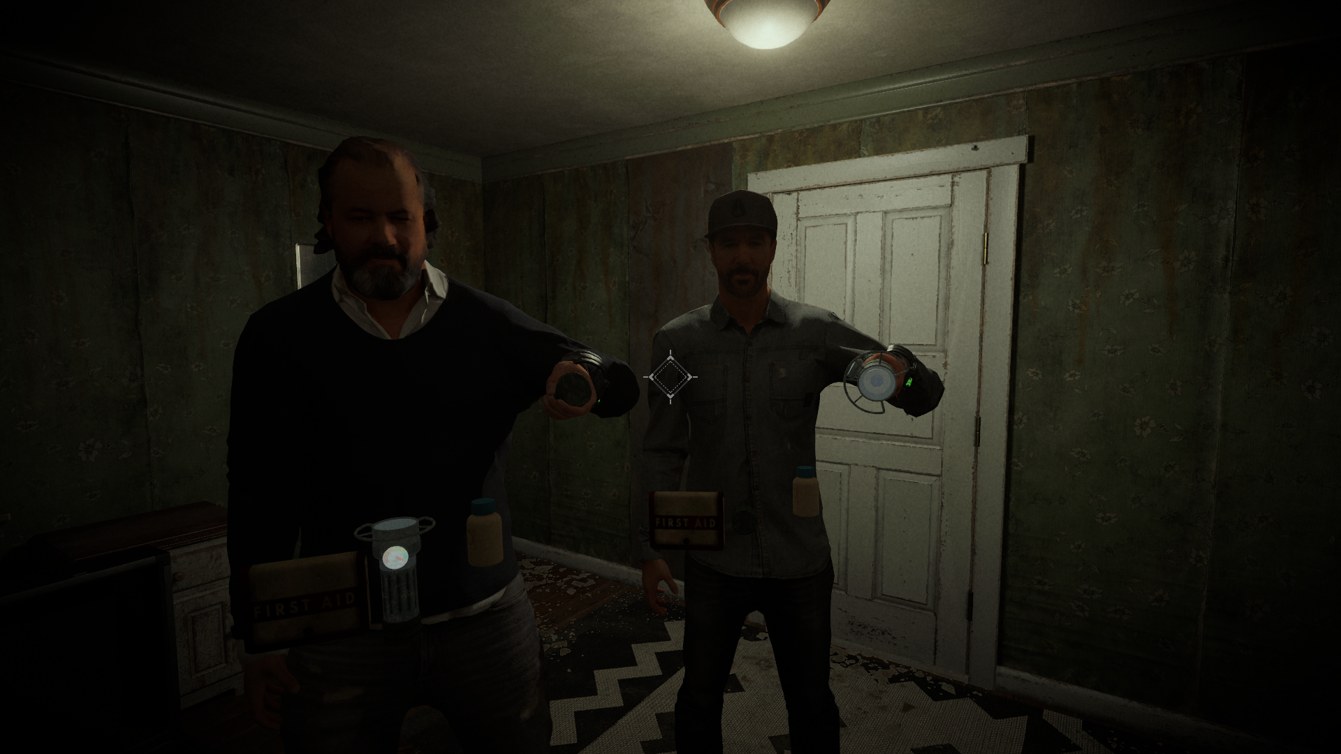 Screenshot of the game. Two player characters face the camera in a small, dark room, holding various equipment. 