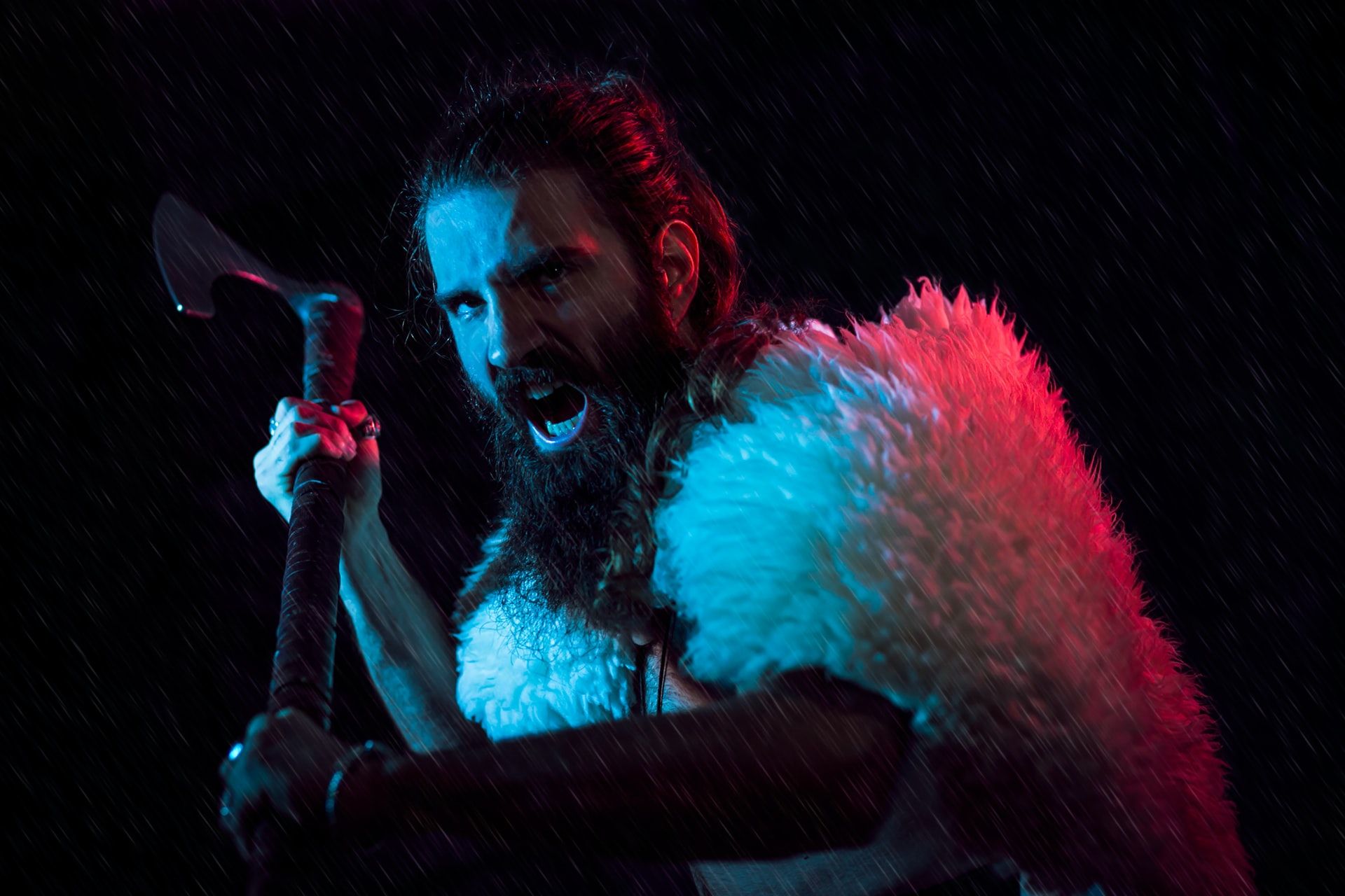 A man bearing an ax and opening his mouth in a yell. He has long hair and a beard, and wears a white fur cloak.